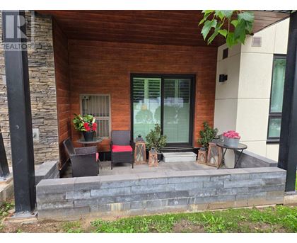 A patio with a table and chairs is in front of a house.