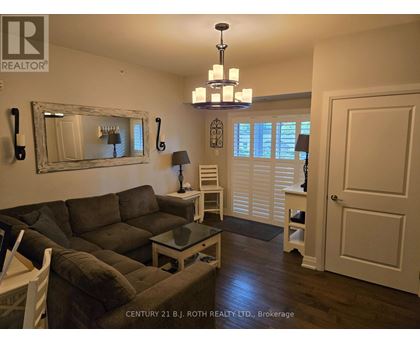 A living room with a grey couch and a chandelier.