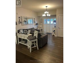 A living room with a grey couch and a white chair.