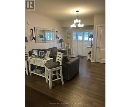 A living room with a grey couch and a white chair.
