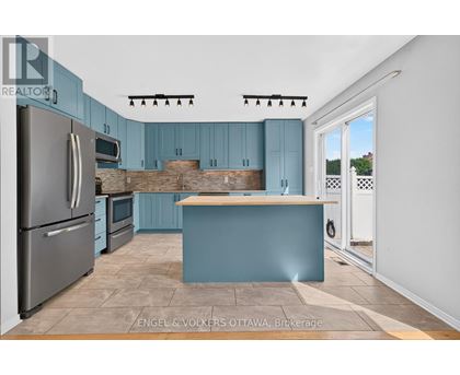 A kitchen with blue cabinets and a wooden counter.