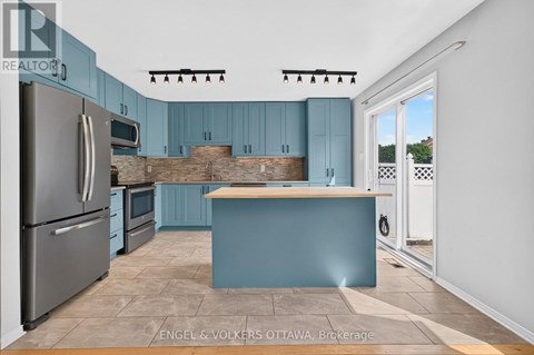 A kitchen with blue cabinets and a wooden counter.