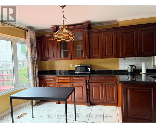 A kitchen with brown cabinets and a black table.