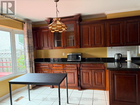 A kitchen with brown cabinets and a black table.