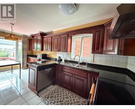 A kitchen with dark wood cabinets and a black counter top.