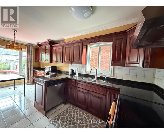 A kitchen with dark wood cabinets and a black counter top.