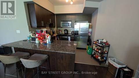 A kitchen with granite countertops and a bar area with stools.