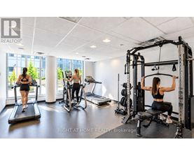 A woman is working out on a cable machine in a well-equipped gym.