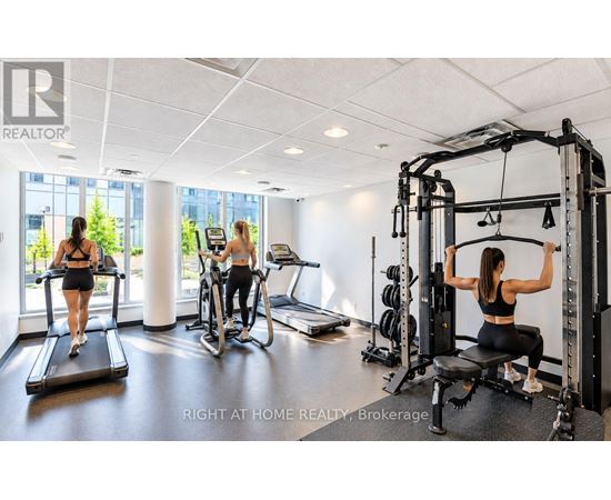 A woman is working out on a cable machine in a well-equipped gym.