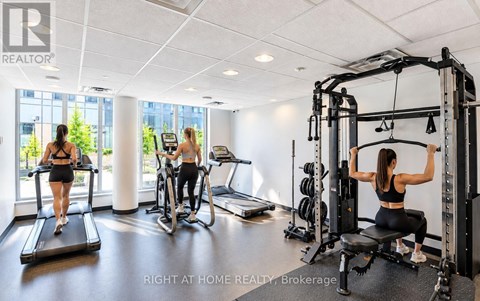 A woman is working out on a cable machine in a well-equipped gym.