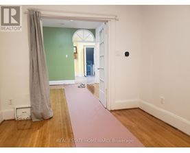 A room with a green wall and a doorway leading to another room.