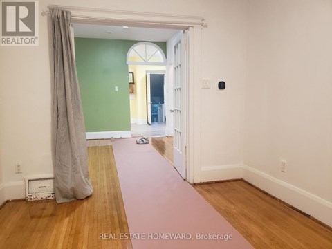 A room with a green wall and a doorway leading to another room.