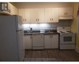A kitchen with white appliances and cabinets.