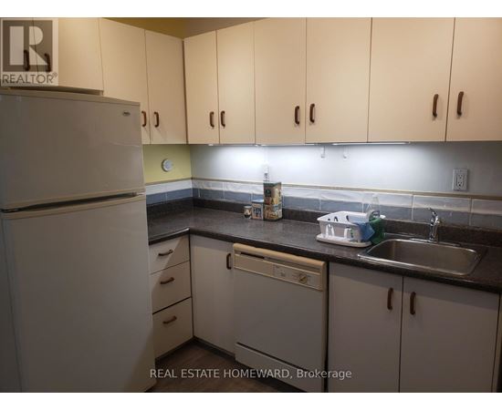 A kitchen with white cabinets and a white refrigerator.