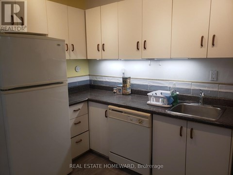 A kitchen with white cabinets and a white refrigerator.
