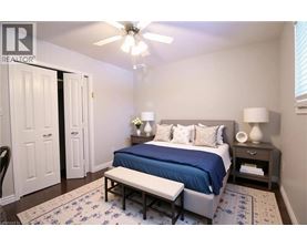 A bedroom with a bed, bench, and two lamps.