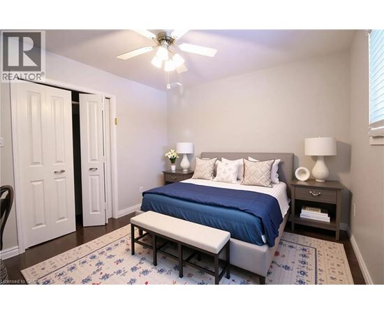 A bedroom with a bed, bench, and two lamps.