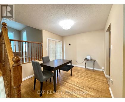 A dining room with a wooden table and chairs.