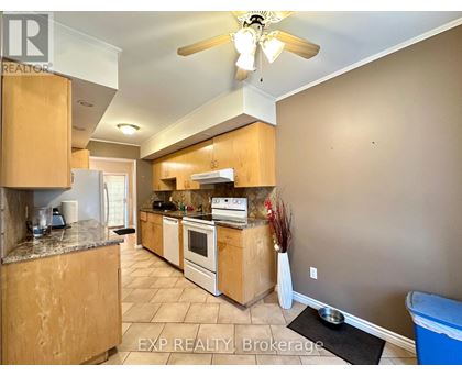 A kitchen with wooden cabinets and a marble countertop.