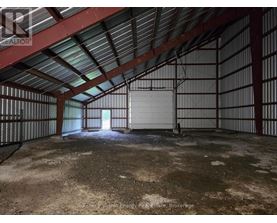 A large, empty, industrial-looking room with a metal roof and walls.