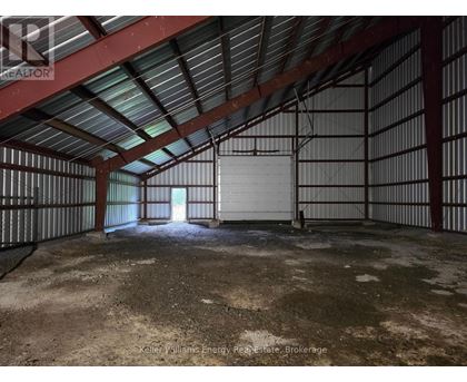 A large, empty, industrial-looking room with a metal roof and walls.