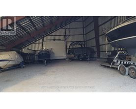 A boat is parked in a garage with a trailer.