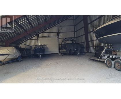 A boat is parked in a garage with a trailer.