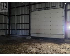 A large, empty warehouse with a sign that reads "REALTOR" in the upper left corner.