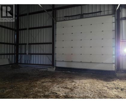 A large, empty warehouse with a sign that reads "REALTOR" in the upper left corner.