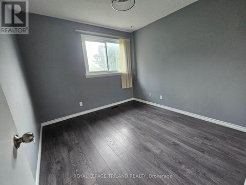 A room with a window and wooden flooring.