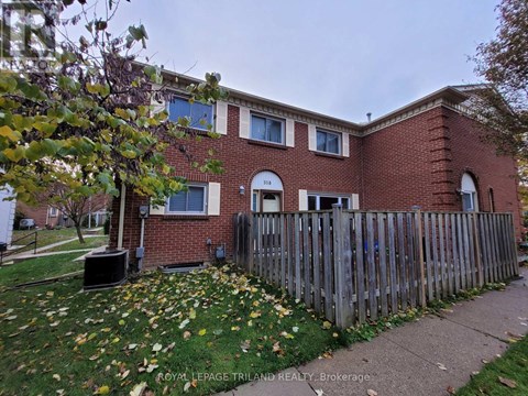 A brick house with a fence in front of it.