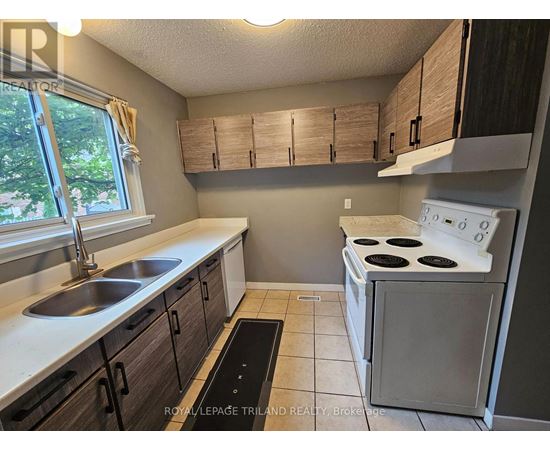 A kitchen with a white stove and brown cabinets.