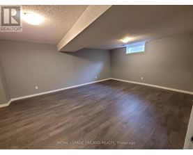 A room with wooden flooring and a window on the wall.