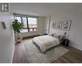 A bedroom with a large bed and a potted plant.