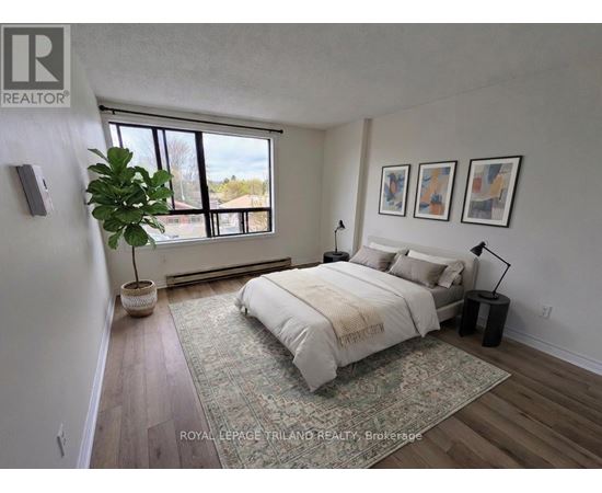A bedroom with a large bed and a potted plant.