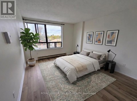 A bedroom with a large bed and a potted plant.