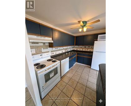 A kitchen with a white stove top oven and a white dishwasher.