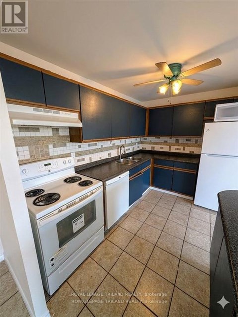 A kitchen with a white stove top oven and a white dishwasher.