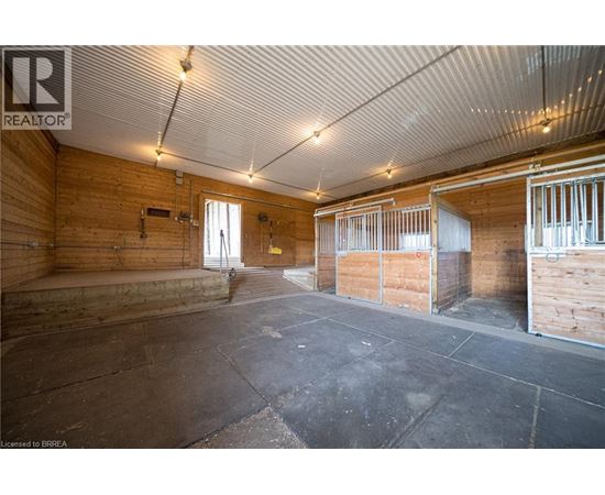 A spacious room with wooden walls and a concrete floor.