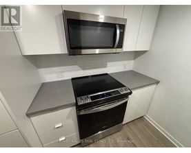 A modern kitchen with a stainless steel oven and microwave above it.