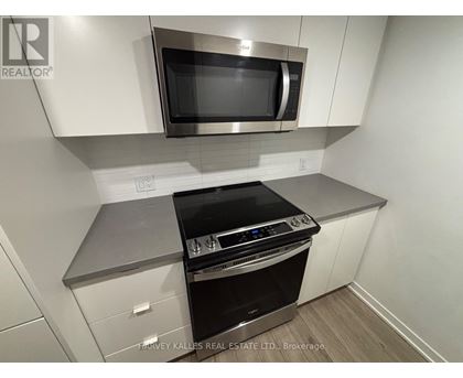 A modern kitchen with a stainless steel oven and microwave above it.
