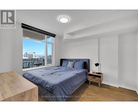 A bedroom with a large bed and a view of the city through the window.