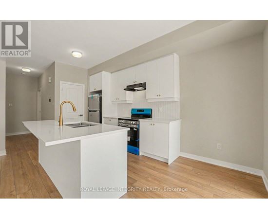 A kitchen with white cabinets and a white island.