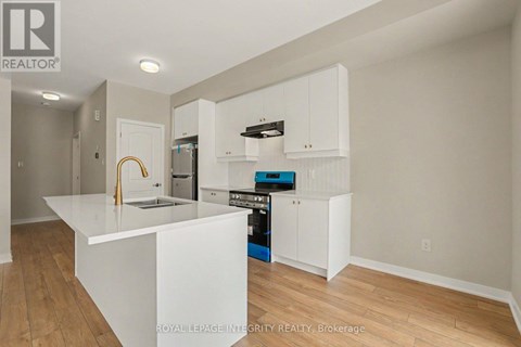 A kitchen with white cabinets and a white island.
