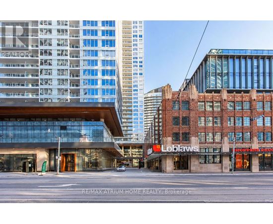 A modern building with a glass facade is in the background, while a Loblaws grocery store is in the foreground.