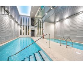 A swimming pool inside a building with a glass wall.