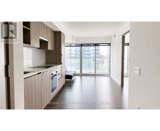 A modern kitchen with wooden cabinets and a large window.
