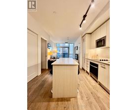 A kitchen with wooden floors and white cabinets.