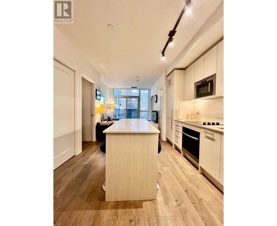 A kitchen with wooden floors and white cabinets.