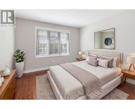 A well-lit bedroom with a large bed and a potted plant.